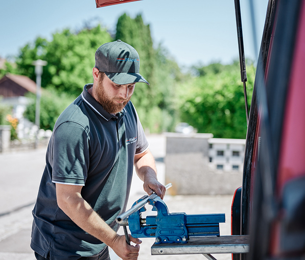 Handwerker arbeitet mit Werkzeug an einem Fahrzeug, um Materialien für ein Bauprojekt vorzubereiten.